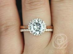 a woman's hand with a diamond ring on top of her finger and an engagement band