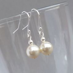 I have used 8mm cream Swarovski pearls to create these simple cream pearl drop earrings. The minimal design and the lustre of the pearls make these ivory dangly earrings perfect for wearing everyday or for a special occasion. Each ivory pearl drop dangles 15mm from the bottom of the Sterling silver ear hook. All of the metal elements used to create these dangle earrings are Sterling silver. You will receive your earrings with a complimentary pair of plastic stoppers to ensure they stay securely in place. Your jewellery will arrive gift wrapped and ready to present as a gift or enjoy as a treat to yourself. To ensure they arrive safely, all of my parcels are packaged with care. --------------------- Matching items available --------------------- Cream floating necklace: https://www.etsy.com Floating Pearl Necklace, Plastic Stoppers, Simple Jewellery, Fused Glass Necklace, Wedding Jewelry For Bride, Everyday Jewellery, Long Silver Earrings, Earrings Dangle Simple, Jewelry King