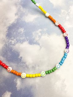 Necklace with rainbow beads and smiley charms. Casual Rainbow Beaded Necklaces For Festivals, Casual Rainbow Beaded Necklace For Festivals, Fun Rainbow Necklaces With Colorful Beads, Trendy Rainbow Necklaces With Heart Beads, Trendy Rainbow Necklace With Heart Beads, Casual Rainbow Round Beads Necklace, Casual Rainbow Round Beaded Necklace, Funky Rainbow Jewelry With Colorful Beads, Trendy Rainbow Necklace For Festivals