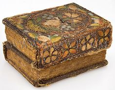 an old wooden box with decorative designs on the lid and sides, sitting on a white surface