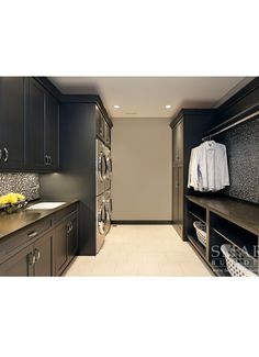 a laundry room filled with lots of cabinets and drawers next to a washer and dryer