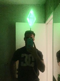 a man taking a selfie in front of a mirror with green lights on it