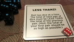 two dices sitting on top of a table next to a sign that says less than