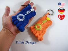 a crocheted keychain is being held by a person's hand