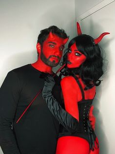 a man and woman dressed in devil costumes