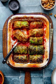 stuffed cabbage rolls in a casserole dish with sauce