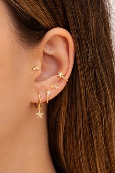 a woman wearing an ear cuff with three stars on the front and back of her ear