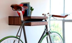 a bicycle parked next to a window in front of a book shelf with books on it