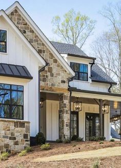 a large white house with two story windows and black shutters on the front door