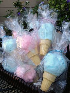 some ice cream cones wrapped in plastic bags on a wicker basket next to potted plants