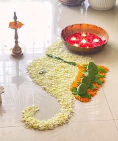 flowers and candles are laid out on the floor to be used for diwaling