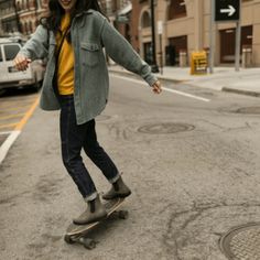 a woman riding a skateboard down the middle of a street