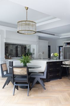 a large kitchen with an island and dining table in the center, surrounded by chairs