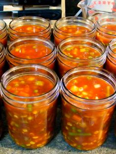 several jars filled with soup sitting on top of a counter