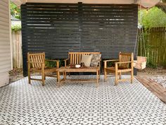 a patio with wooden chairs and an umbrella