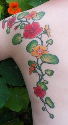 a woman's back with flowers and leaves on it