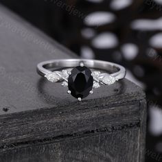 a black and white diamond ring sitting on top of a wooden table