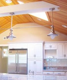 a kitchen with white cabinets and wooden ceiling