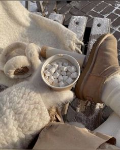 a person's feet are shown with marshmallows in a white bowl