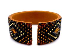 "Made using genuine Guatemalan leather and exquisite glass beads, this cuff bracelet gives off an elegant and luxurious feel. Its unique patterns are brilliantly colored with strong Native American influences. Every piece in our collection is hand stitched with impeccable precision and detail. They are designed to make you feel bold and empowered! Flexible cuff fits all-sized adult wrists Band width measures approximately 3/4\" Handmade in Guatemala *Please note that all of our items are handcra Leather Beaded Bracelets With Round Beads For Gift, Handmade Adjustable Beaded Bracelets For Formal Occasions, Leather Bracelets With Round Beaded Details, Brown Beaded Cuff Bracelet Bangle, Brown Beaded Bangle Cuff Bracelet, Brown Beaded Cuff Bracelet, Bohemian Beaded Bracelets For Formal Occasions, Formal Adjustable Bangle Beaded Bracelets, Elegant Leather Beaded Bracelets