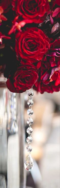 red roses in vases with crystal beads on the bottom, and hanging from them