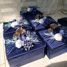 several blue boxes with flowers on them sitting on a counter next to other boxes and napkins