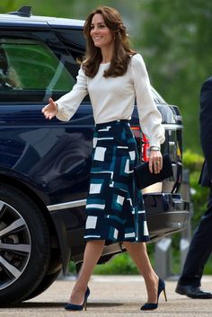 the duke and duchess of cambridge are walking towards a car with their hands out to each other