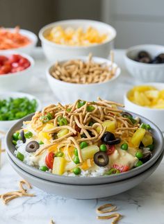 a bowl filled with rice and vegetables on top of a table next to other bowls