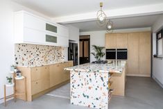 a kitchen with marble counter tops and wooden cabinets, along with an island in the middle