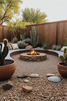 an outdoor fire pit surrounded by rocks and cacti