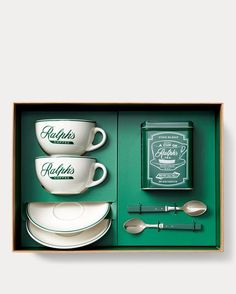 two cups and saucers in a green box