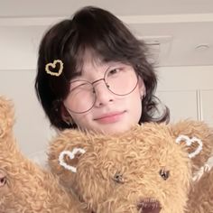 a woman holding two teddy bears in her arms and wearing glasses with hearts on them