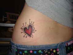 a woman's stomach with a heart tattoo on her belly and stars around it