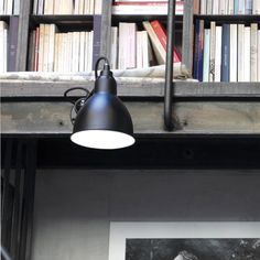 two black lamps are next to a bookshelf with many books on the shelves