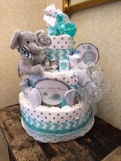 a diaper cake that has an elephant on top and blue trim around the edges