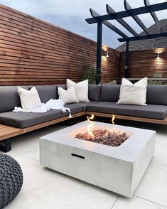 a fire pit sitting on top of a white tile floor next to a wooden fence