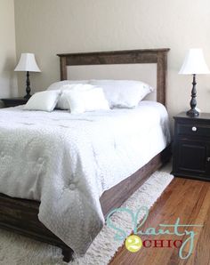 a bed with white linens and pillows in a small room next to two lamps