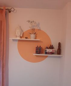 two shelves with vases, books and other items on them against a wall in a bedroom