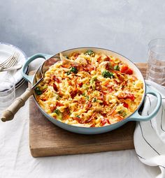 a large casserole dish with broccoli, tomatoes and other toppings