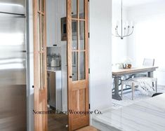 a kitchen with white marble counter tops and stainless steel refrigerator freezer next to a dining room table