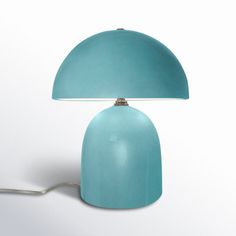 a blue table lamp sitting on top of a white floor next to a light bulb