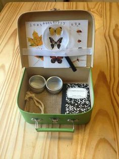 an open suitcase with some items in it sitting on a wooden table next to a cup and saucer