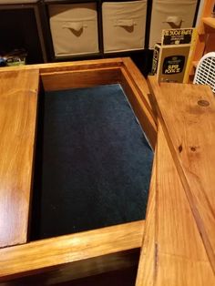 a wooden desk with several storage bins in the back and one drawer open on top