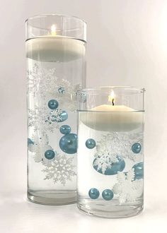 two glass vases filled with candles and snowflakes