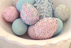 a white bowl filled with blue and pink decorated eggs