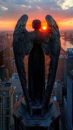 an angel statue with the sun setting behind it in new york city, united states