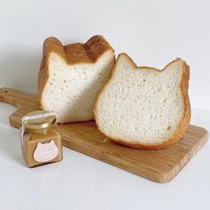 two slices of bread on a cutting board next to a jar of peanut butter