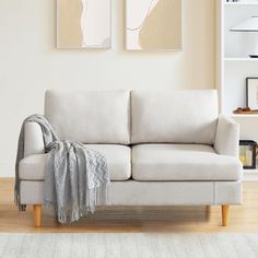 a white couch with a blanket on top of it