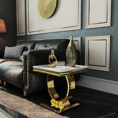 a living room with black leather couches and gold accents on the wall above them