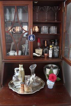 an old china cabinet with wine glasses and bottles